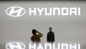 FILE PHOTO: Visitors take photographs in front of the logo of Hyundai Motor during the 2019 Seoul Motor Show in Goyang