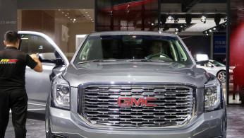 FILE PHOTO: Staff member cleans a General Motors Company (GMC) vehicle displayed at the second China International Import Expo (CIIE) in Shanghai