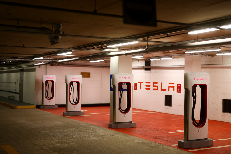 A Tesla electric charging point stands unused in a car park