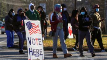 A sign is seen as voters line up for the U.S. Senate run-off election, at a polling location in Marietta, Georgia