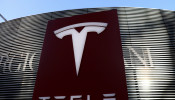 Logo of the electric vehicle maker Tesla is seen near a shopping complex in Beijing
