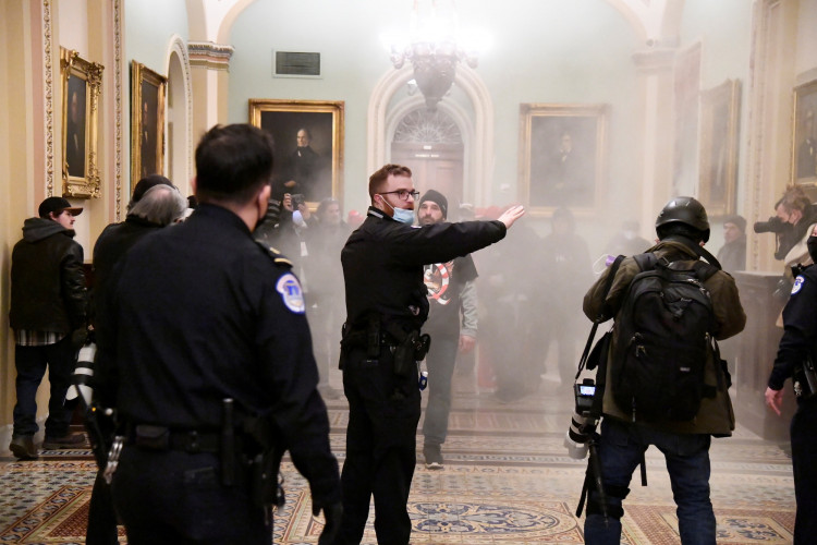 A security officer gestures after supporters of U.S. President Donald Trump breached security defenses at the U.S. Capitol