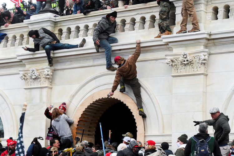 Supporters of U.S. President Donald Trump climb on walls at the U.S. Capitol 