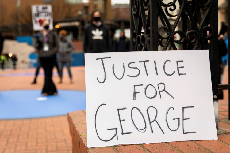 A "justice for George" sign is displayed while people demonstrate as jury selection begins in Minneapolis for the trial of Derek Chauvin, the former policeman accused of killing George Floyd.