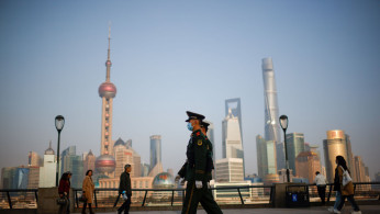 Paramilitary police officers march at the Bund, in front of Lujiazui financial district of Pudong.