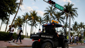 Police officers patrol Ocean Drive during Spring Break in Miami.