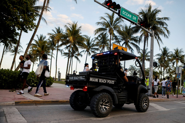 Police officers patrol Ocean Drive during Spring Break in Miami.