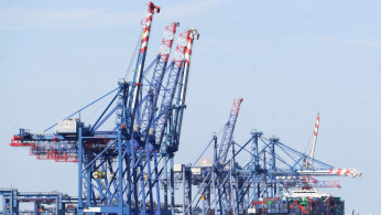 Boats are seen as container ship is beside cranes at the Suez canal.