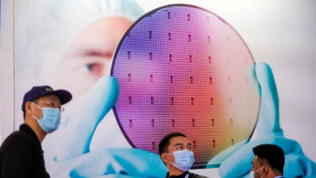 People visit a display of semiconductor device at Semicon China, a trade fair for semiconductor technology, in Shanghai, China.