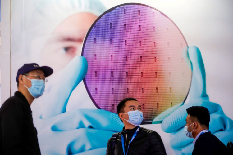 People visit a display of semiconductor device at Semicon China, a trade fair for semiconductor technology, in Shanghai, China.