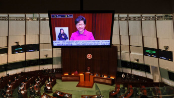 Hong Kong Chief Executive Carrie Lam is seen on a screen as she attend her quarterly update.