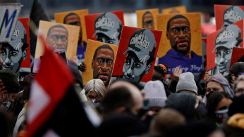 People hold placards after the verdict in the trial of former Minneapolis police officer Derek Chauvin.