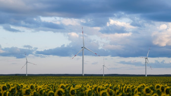 Wind turbines are seen in sunflower field during sunset outside Ulyanovsk, Russia.