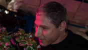 NASA astronaut and Expedition 64 flight engineer Michael Hopkins smells ‘Extra Dwarf’ pak choi plants growing aboard the International Space Station