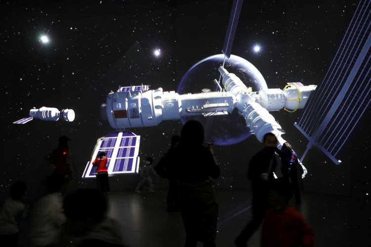 FILE PHOTO: Visitors stand near a giant screen displaying the images of the Tianhe space station 