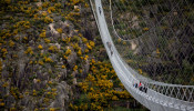 People walk on the world's longest pedestrian suspension bridge '516 Arouca', now open for local residents in Arouca, Portugal
