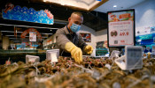 A staff member lays out seafood at a supermarket following an outbreak of the coronavirus disease (COVID-19) in Beijing, China.