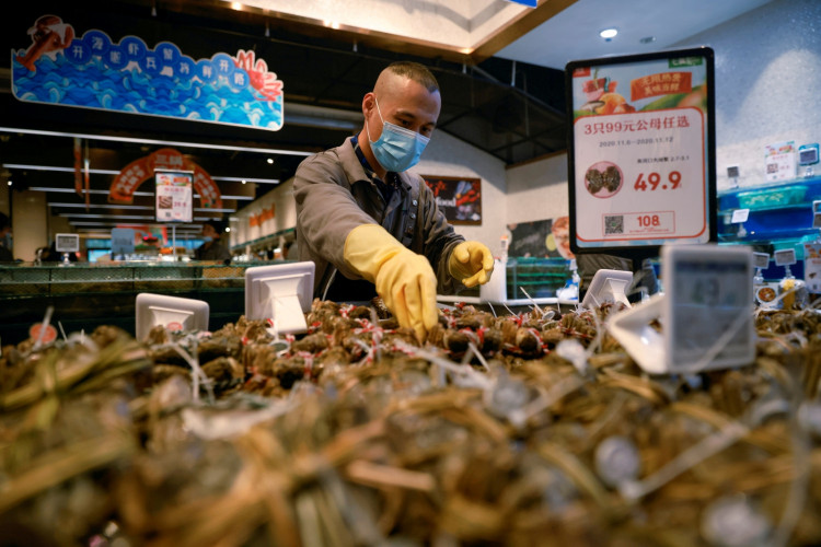 A staff member lays out seafood at a supermarket following an outbreak of the coronavirus disease (COVID-19) in Beijing, China.