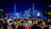 People walk along near the Bund, in front of Lujiazui financial district of Pudong, China.