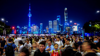 People walk along near the Bund, in front of Lujiazui financial district of Pudong, China.