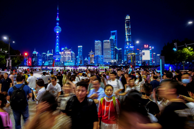 People walk along near the Bund, in front of Lujiazui financial district of Pudong, China.
