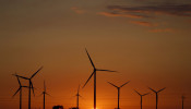 FILE PHOTO: A sunset is seen through a wind farm near Puck, northern Poland, July 22, 2015. 