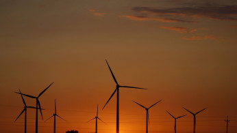 FILE PHOTO: A sunset is seen through a wind farm near Puck, northern Poland, July 22, 2015. 