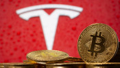 FILE PHOTO: Representations of virtual currency Bitcoin are seen in front of Tesla logo in this illustration taken, February 9, 2021. 