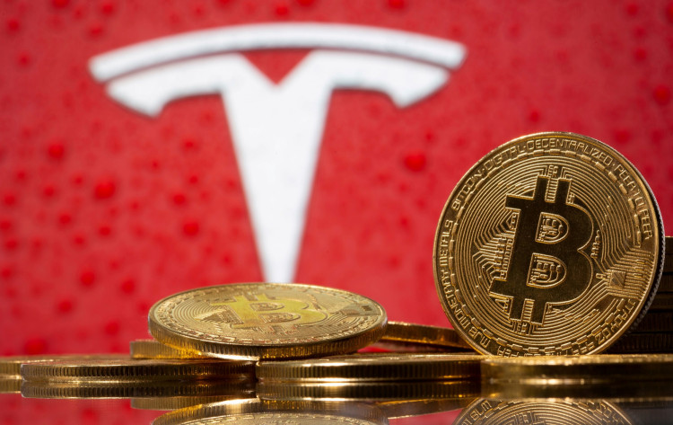 FILE PHOTO: Representations of virtual currency Bitcoin are seen in front of Tesla logo in this illustration taken, February 9, 2021. 