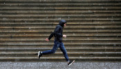 A person runs along Wall Street as heavy rain and hail falls in New York City.