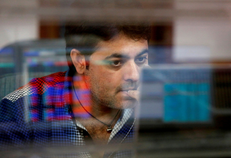 A broker reacts while trading at his computer terminal at a stock brokerage firm in Mumbai, India.