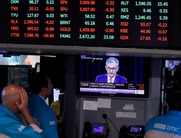 raders look on as a screen shows Federal Reserve Chairman Jerome Powell's news conference.