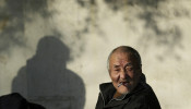 FILE PHOTO: An elderly man smokes on a street in Nanjing, Jiangsu province December 27, 2010.