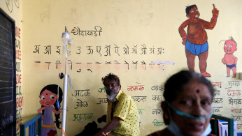 Patients suffering from coronavirus disease (COVID-19) receive oxygen support as they sit inside a classroom turned COVID-19 care facility  