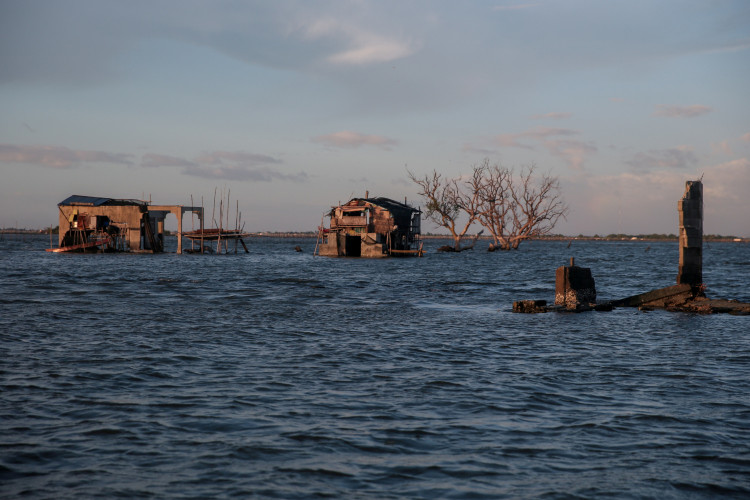 FILE PHOTO: Bamboo huts sit on top of concrete structures in the submerged coastal village Sitio Pariahan, Bulakan, Bulacan, north of Manila, Philippines
