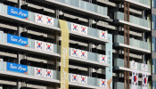 South Korean Flags and signs hang on the appartment building hosting Olympics participants at the Athletes Village