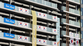South Korean Flags and signs hang on the appartment building hosting Olympics participants at the Athletes Village