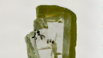 A diamond holding tiny black specks of davemaoite, a mineral formed at high temperature and pressure in the deep Earth.