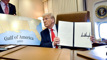 President Donald Trump on Air Force One poses next to a map of the Gulf of America during a flight to New Orleans on February 9, 2025.