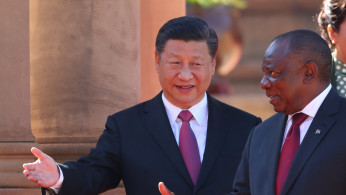 China's President Xi Jinping walks with South African President Cyril Ramaphosa before their meeting in Pretoria