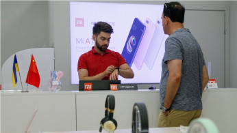 Employee shows a customer a smart watch at the Xiaomi store in central Kiev