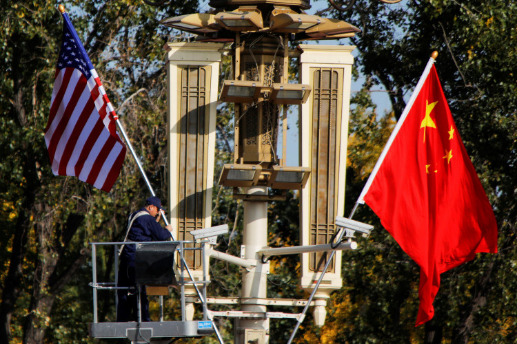 A worker places U.S. and China flags near the Forbidden City ahead of a visit by U.S. President Donald Trump to Beijing, in Beijing