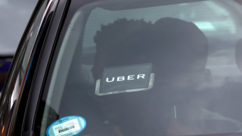 An Uber logo is seen on a car a as it car drives through Times Square in New York City
