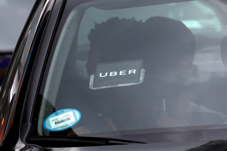 An Uber logo is seen on a car a as it car drives through Times Square in New York City