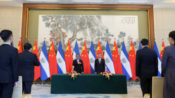 Chinese Foreign Minister Wang Yi and El Salvador's Foreign Minister Carlos Castaneda attend a signing ceremony to establish diplomatic ties between the two countries in Beijing