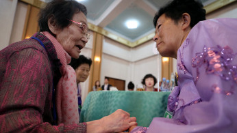 North and South Korean family members talk during a reunion at Mount Kumgang resort