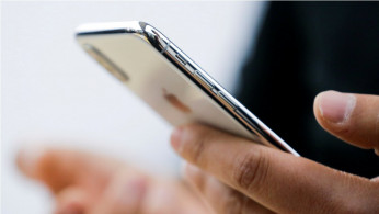 An attendee uses a new iPhone X during a presentation for the media in Beijing