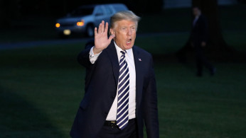 U.S. President Donald Trump waves to journalists