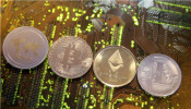 Representations of the Ripple, Bitcoin, Etherum and Litecoin virtual currencies are seen on motherboard in this illustration picture