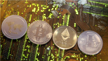 Representations of the Ripple, Bitcoin, Etherum and Litecoin virtual currencies are seen on motherboard in this illustration picture
